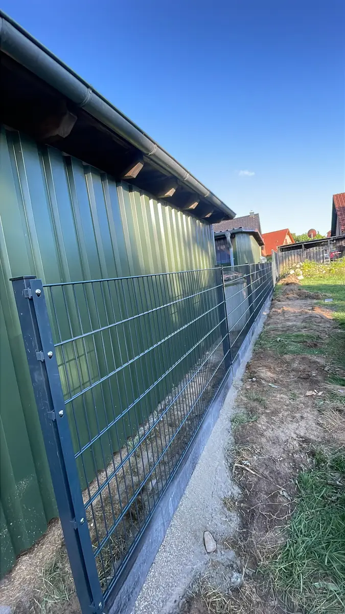Neuer Doppelstabmattenzaun an einer Schuppenwand